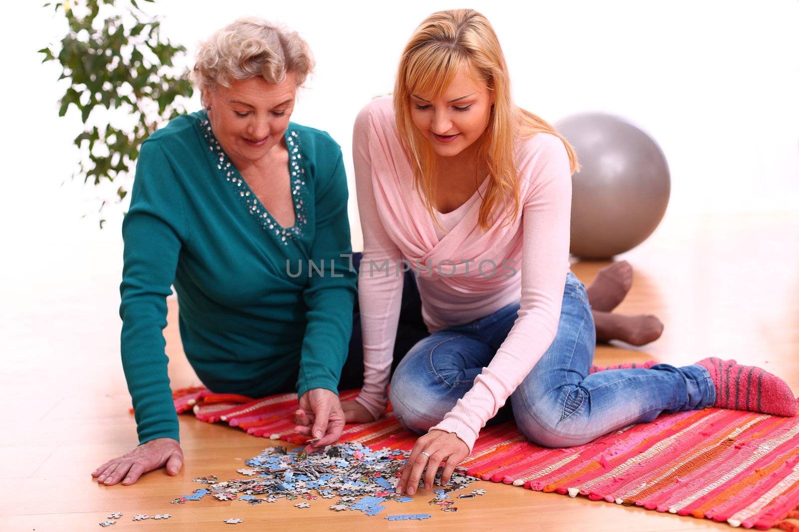 Happy elderly woman with granddaughte playing r at home