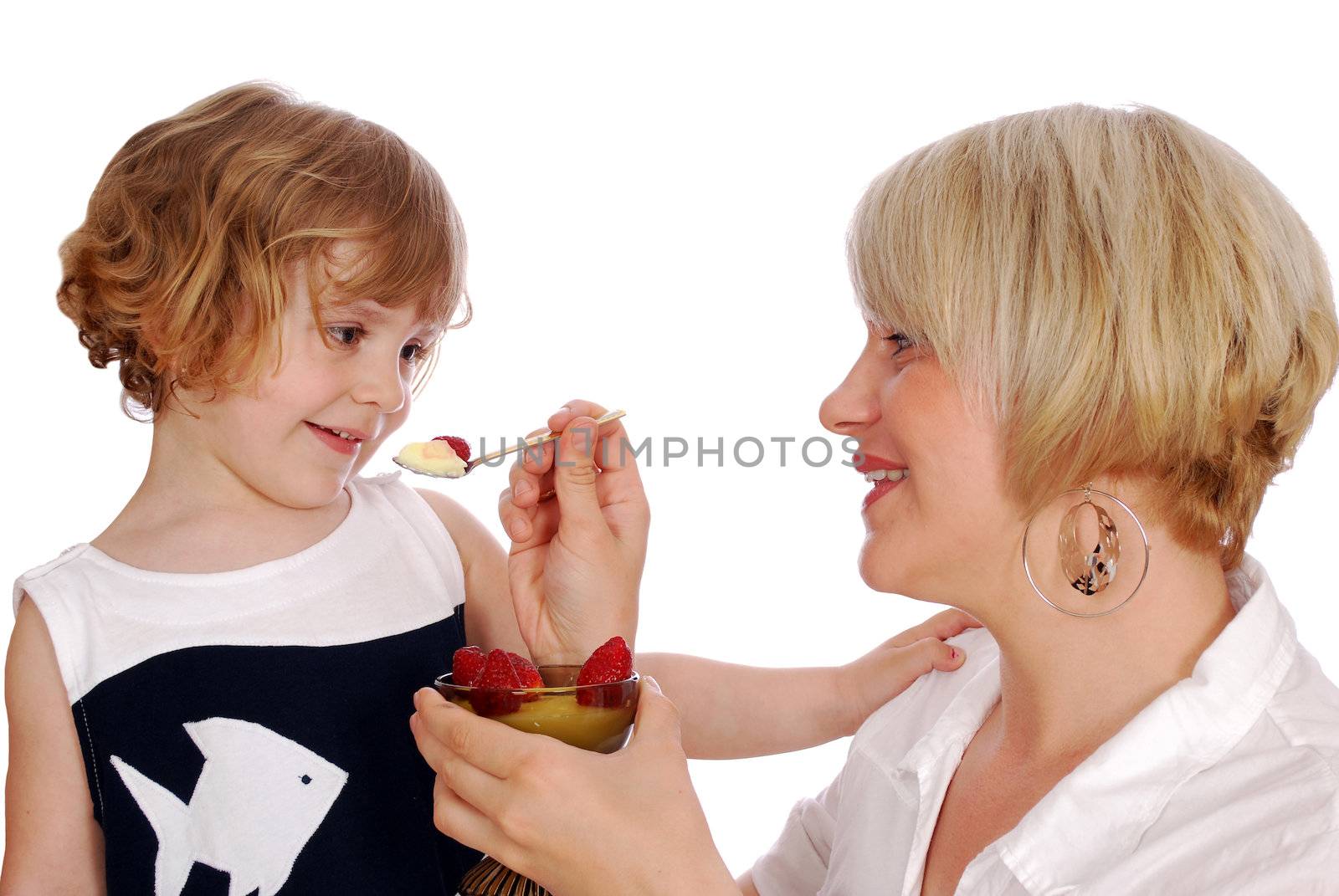 Little girl eating pudding with strawberries