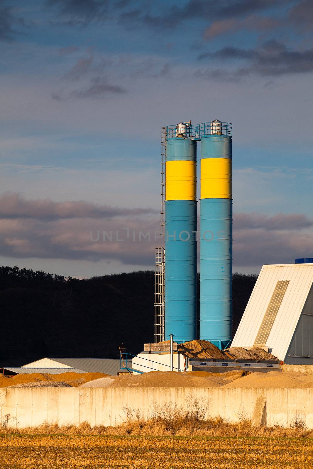 Blue concrete silos at sunset