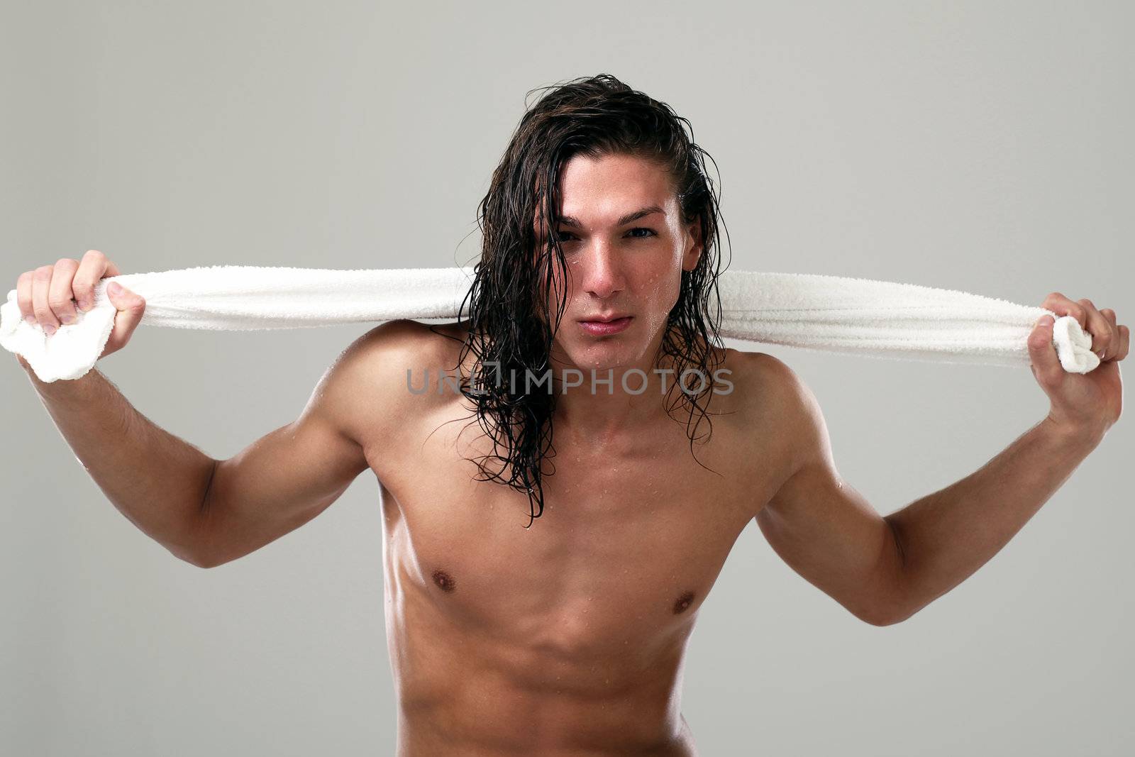 Young sexy man with long hair and towel isolated on white background