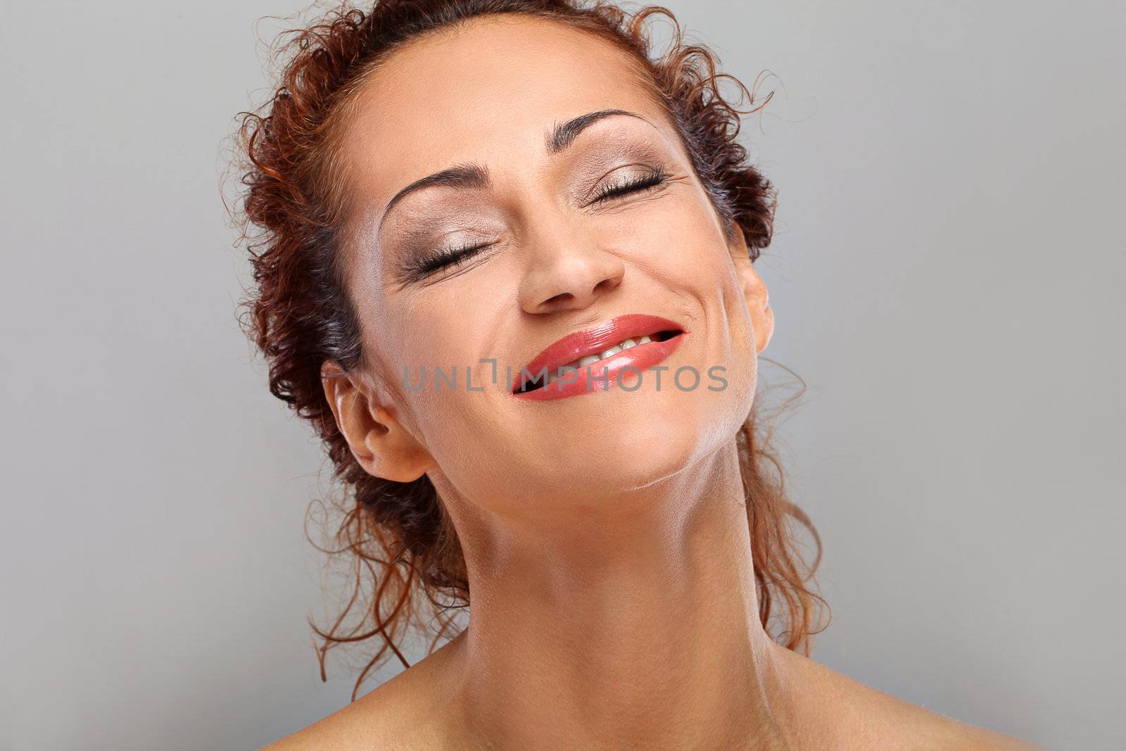 Beautiful natural middle aged woman isolated on grey background