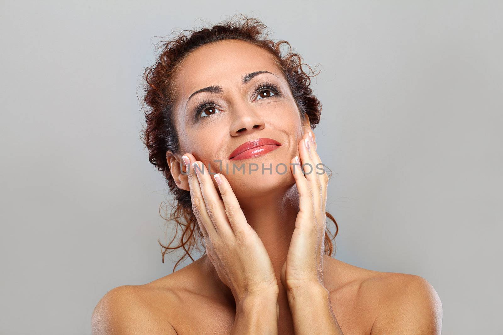 Beautiful natural middle aged woman isolated on grey background