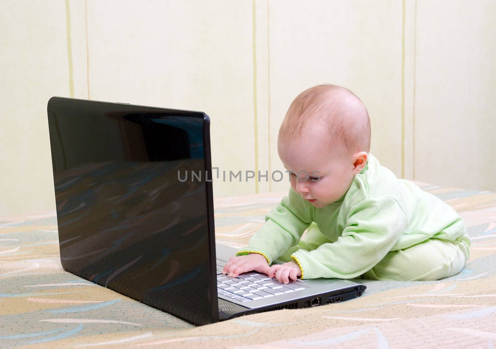 children in diapers playing with a laptop computer by Fanfo