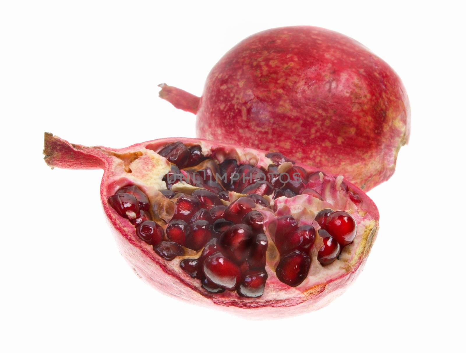 cut pomegranate with seeds around in white background