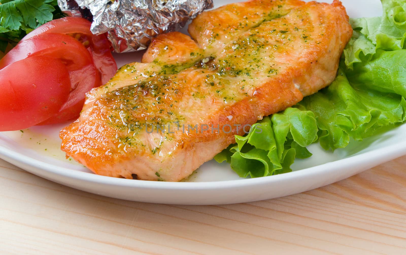 Stake from a salmon with vegetables on a plate. Closeup.