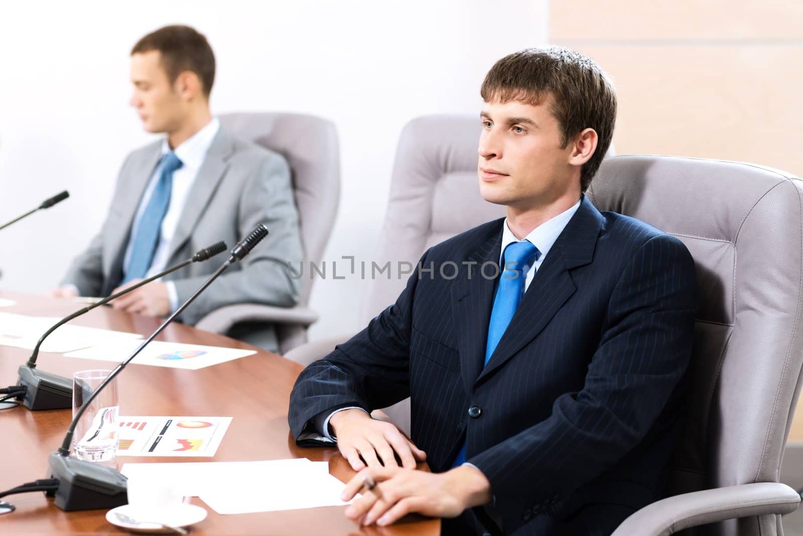 two businessmen sitting in a chair at the table, talk at the conference