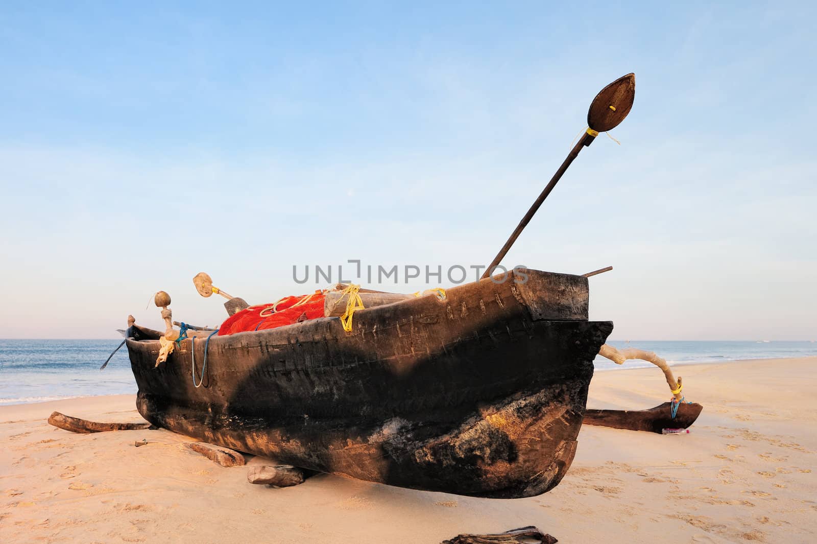 Old fishing boat on the sandy beach in Goa
