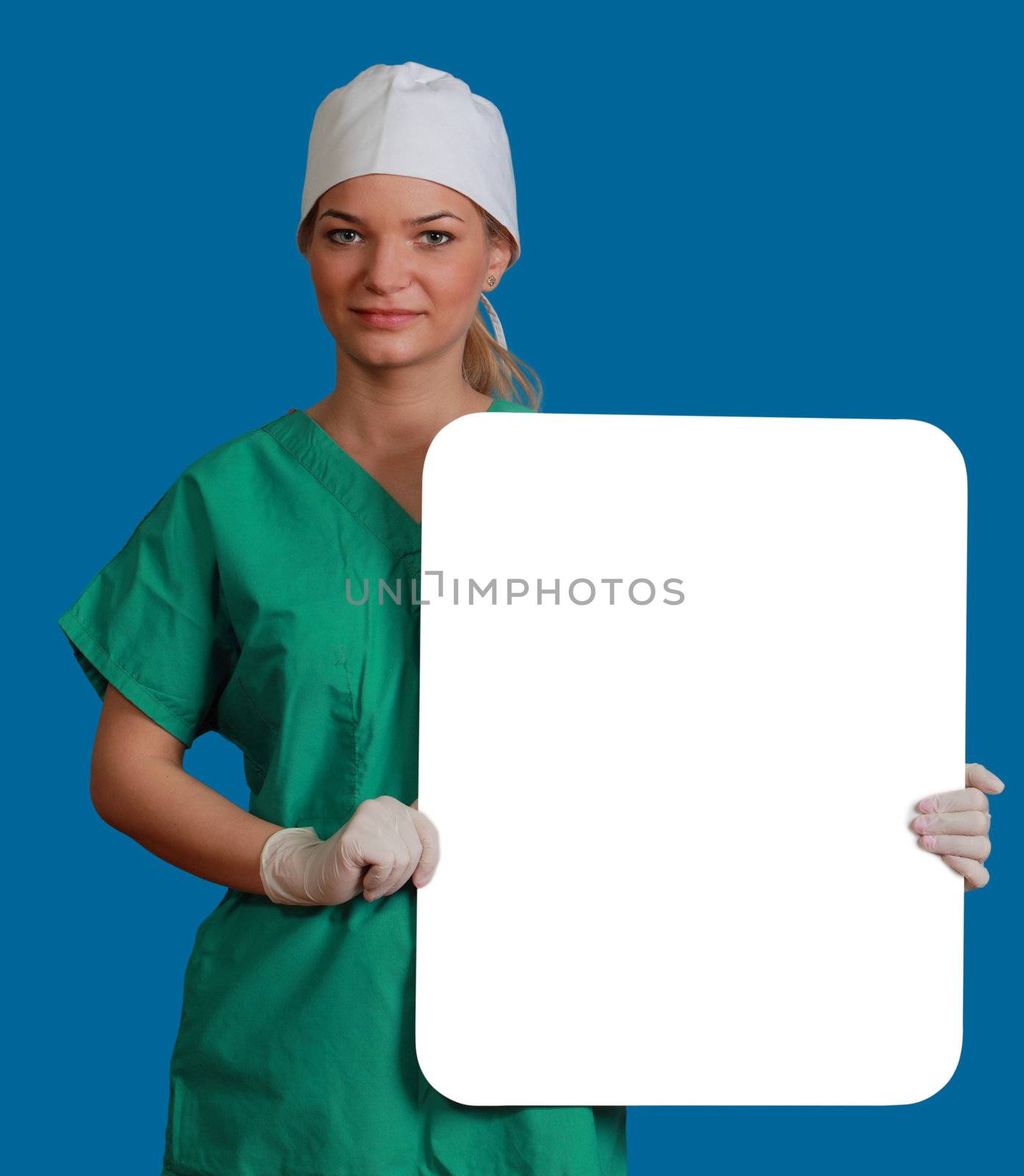 A young woman doctor holding an empty white bill board against a blue background.