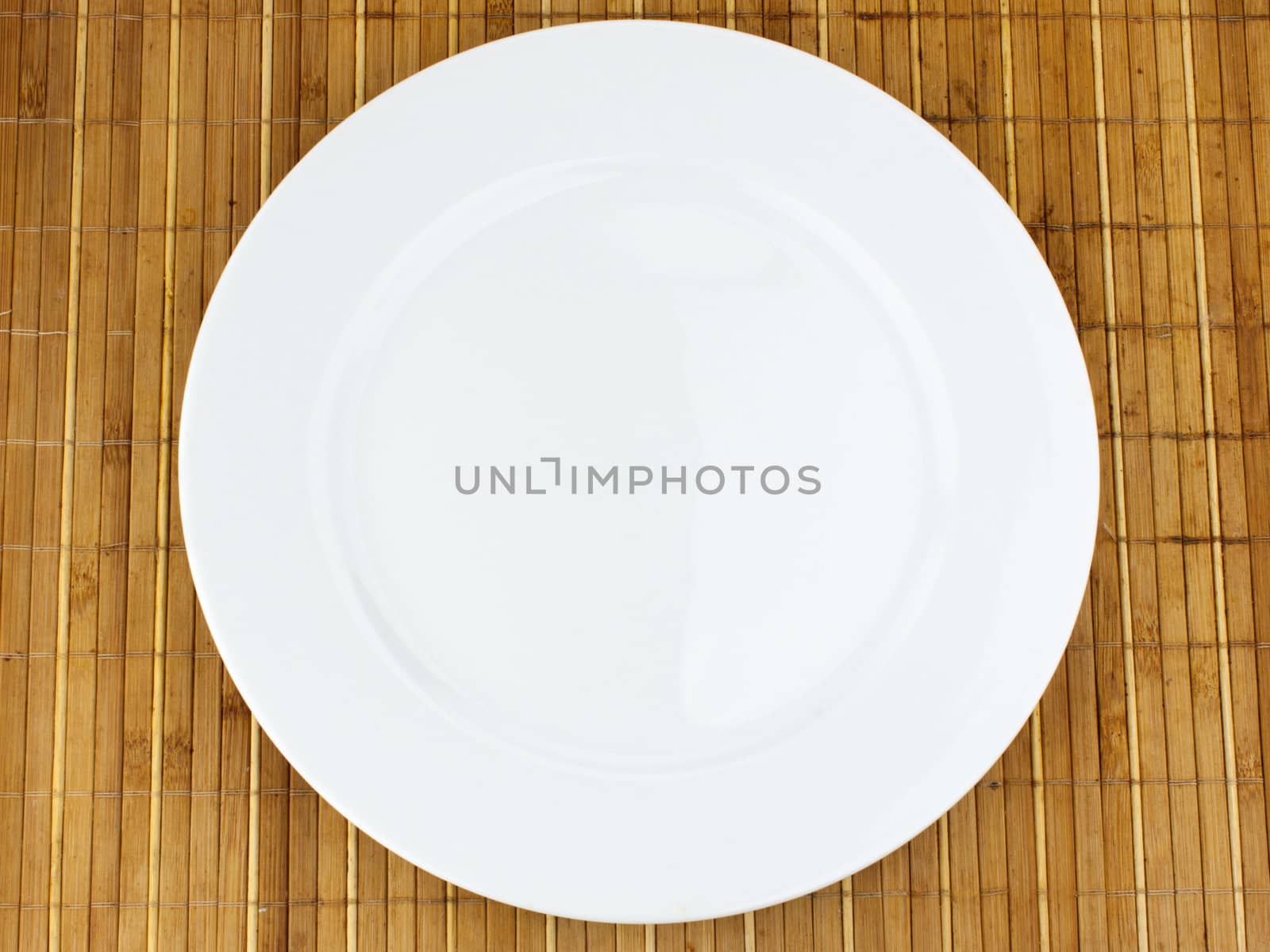 white plate on a bamboo napkin by sfinks