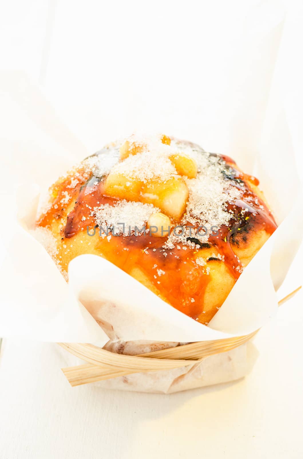 caramel muffin wrapped in baking paper on white plate