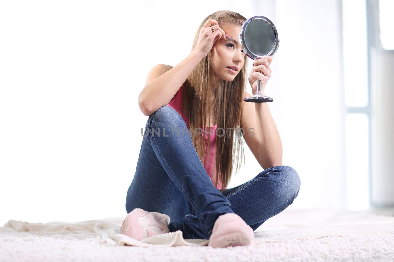 Young long-haired blonde girl sitting on the bed and she pulls out her eyebrows with tweezers and hold the mirror in her hand







Young long-haired blonde sitting on the bed and looks at the mirror