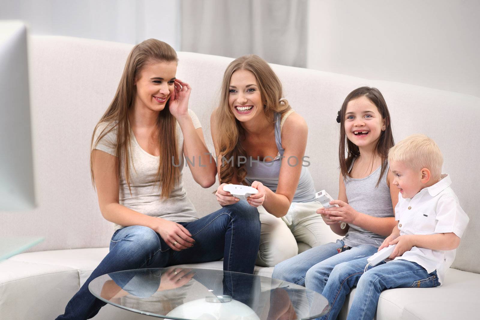 Smiling family playing video games while sitting on the sofa