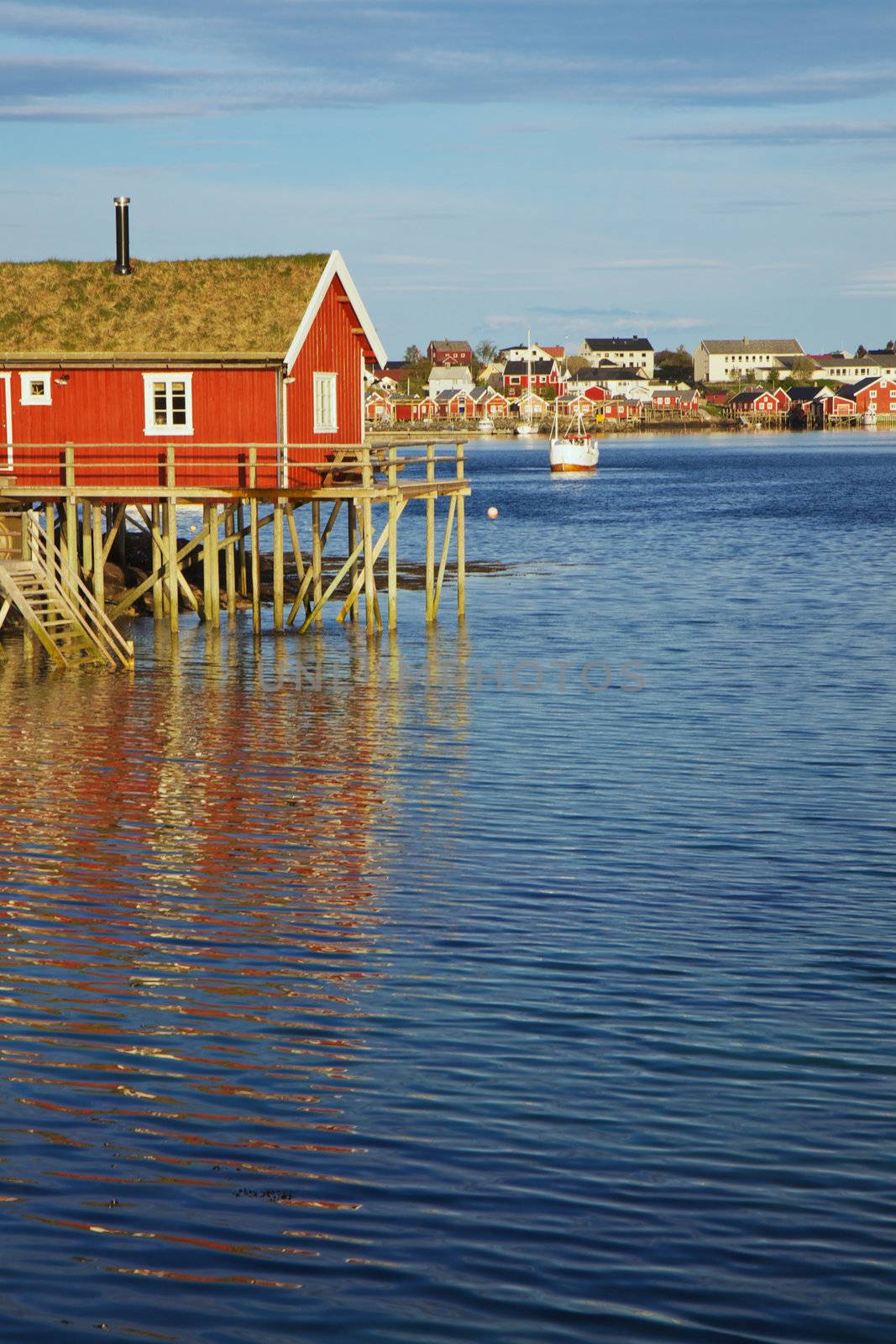 Traditional red rorbu fishing hut with sod roof in town of Reine on Lofoten islands in Norway