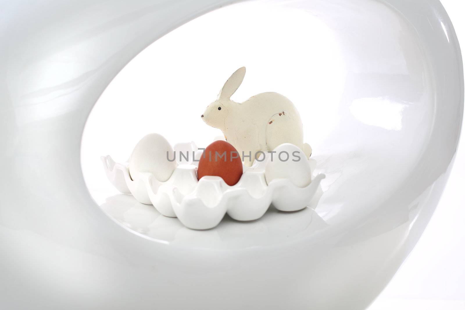 Red easter egg and rabbit on the white plate