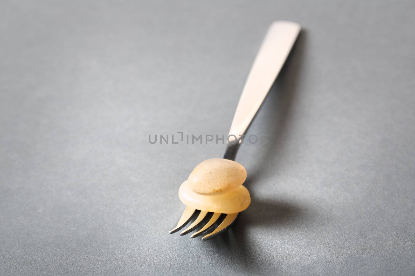 Fork with stones on the grey background