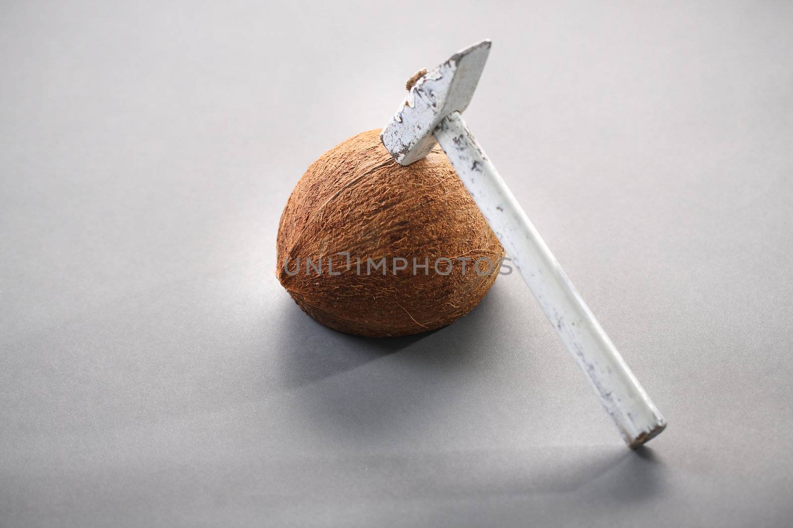 Coconut on white background with a hammer