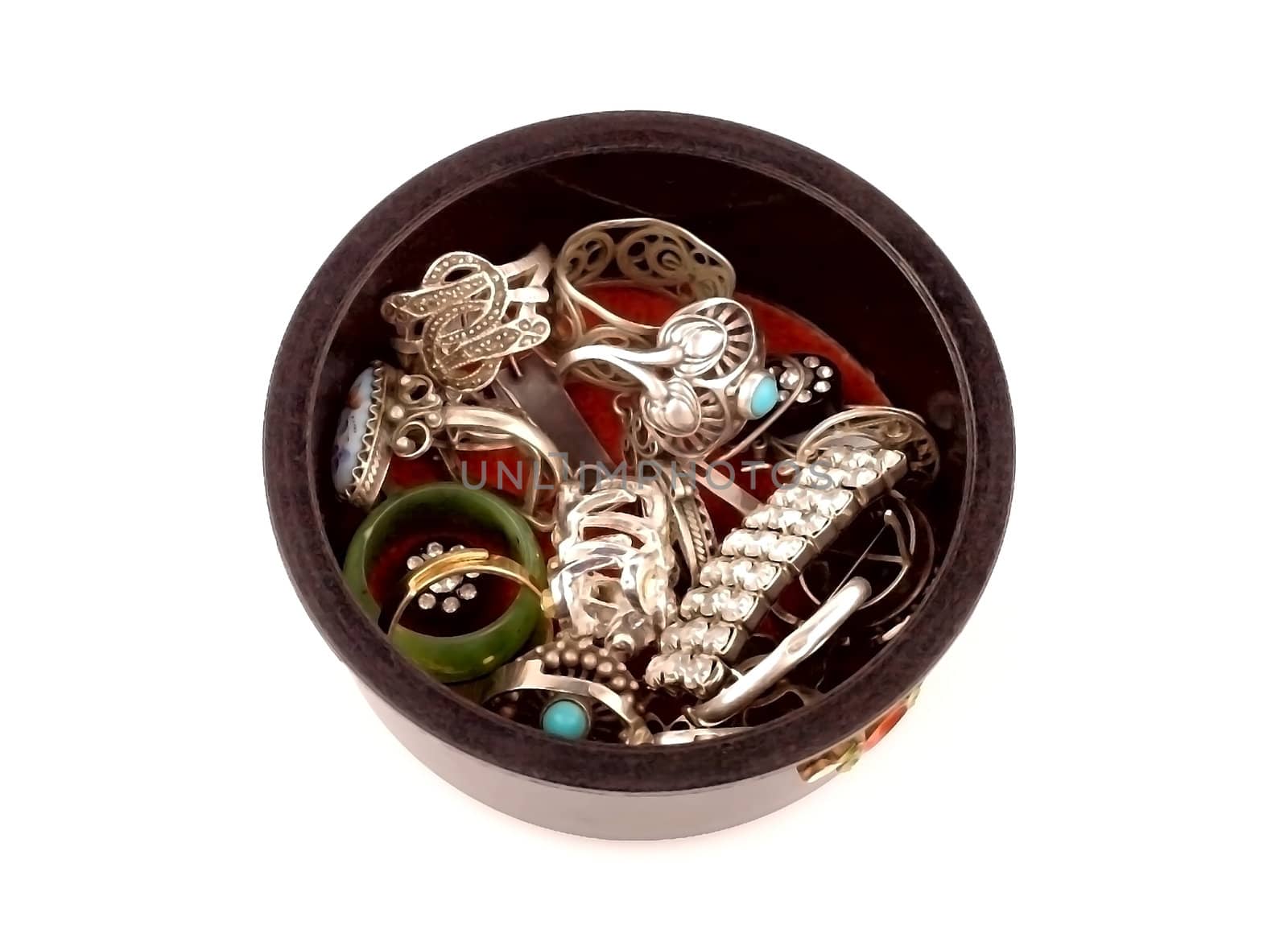 Various women's jewelry in the round box on a white background