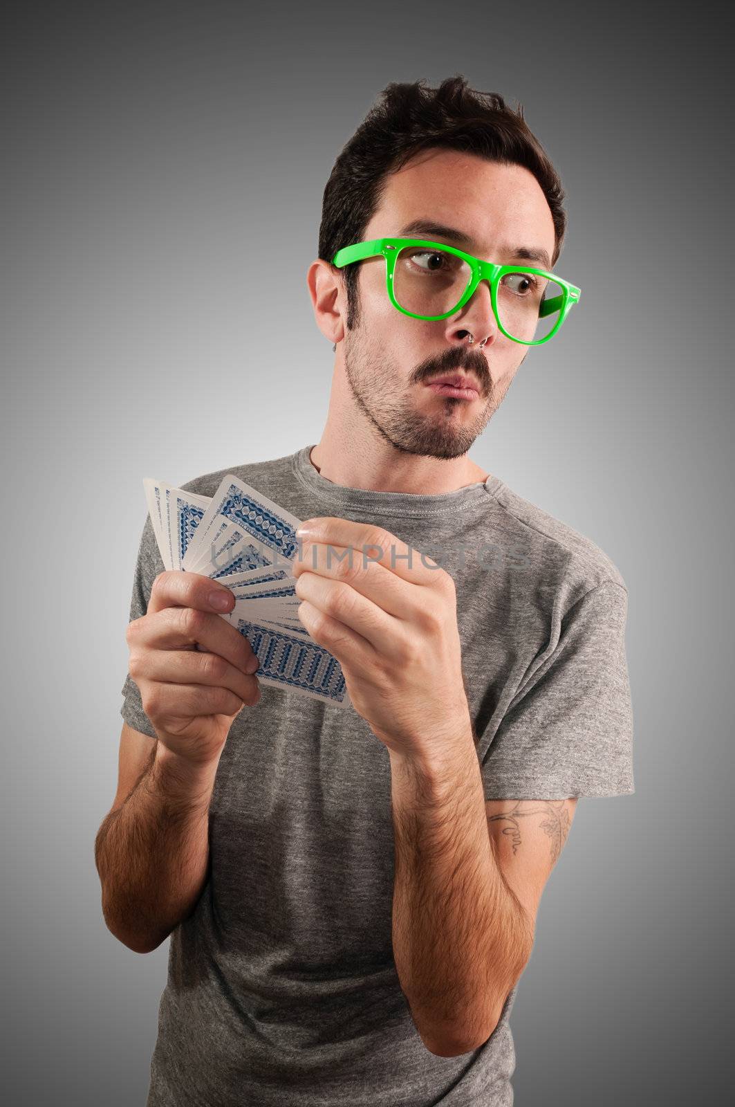 guy spying poker cards on grey background