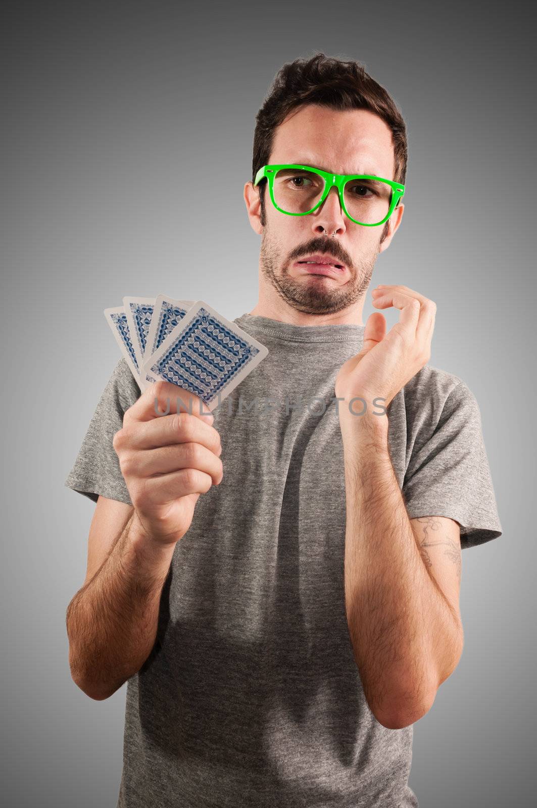 guy holding poker cards on grey background