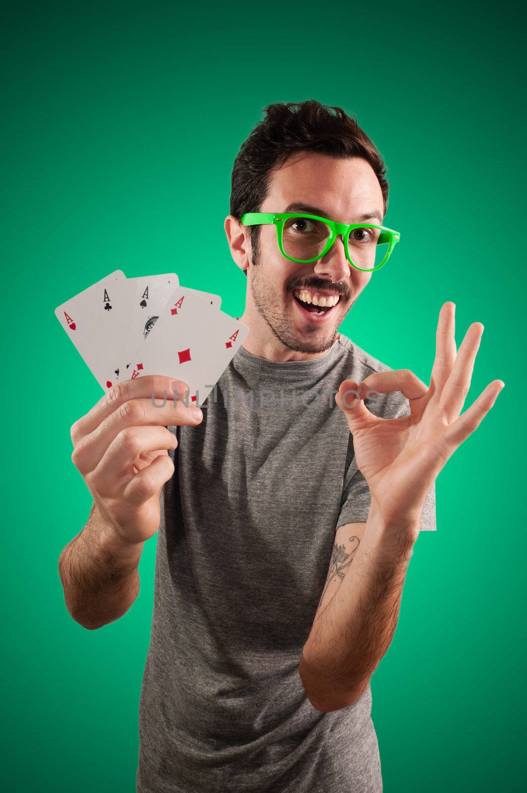 winner guy holding poker cards on green background