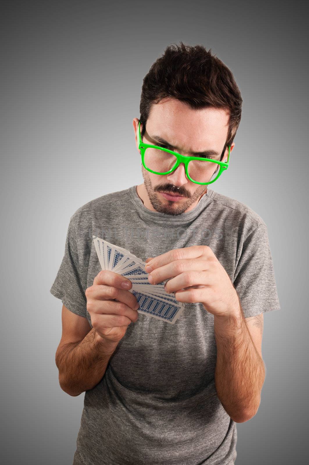 guy holding poker cards on grey background