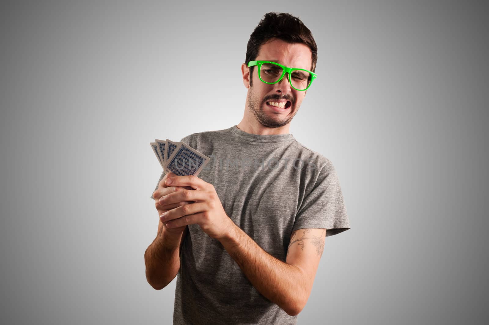 guy holding poker cards on grey background