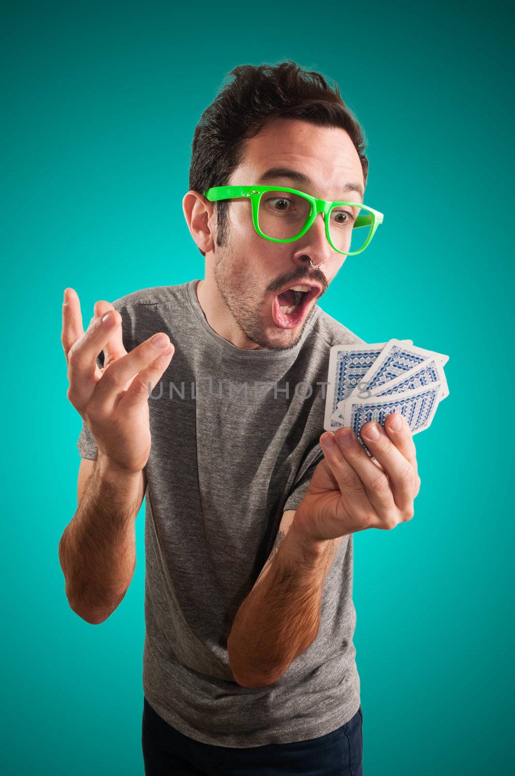 guy holding poker cards on grey background