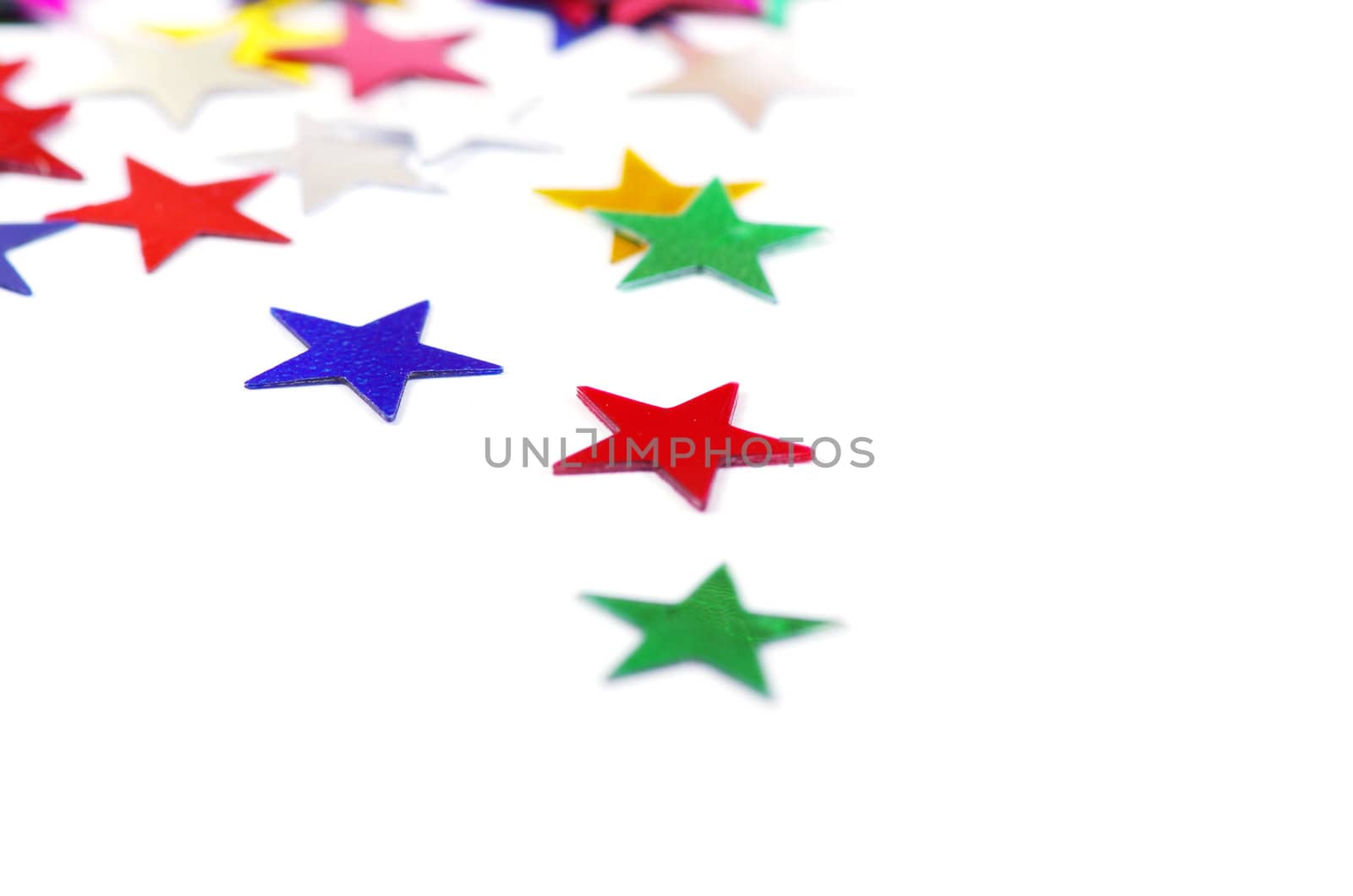 Christmas decoration of colored confetti stars against white background
