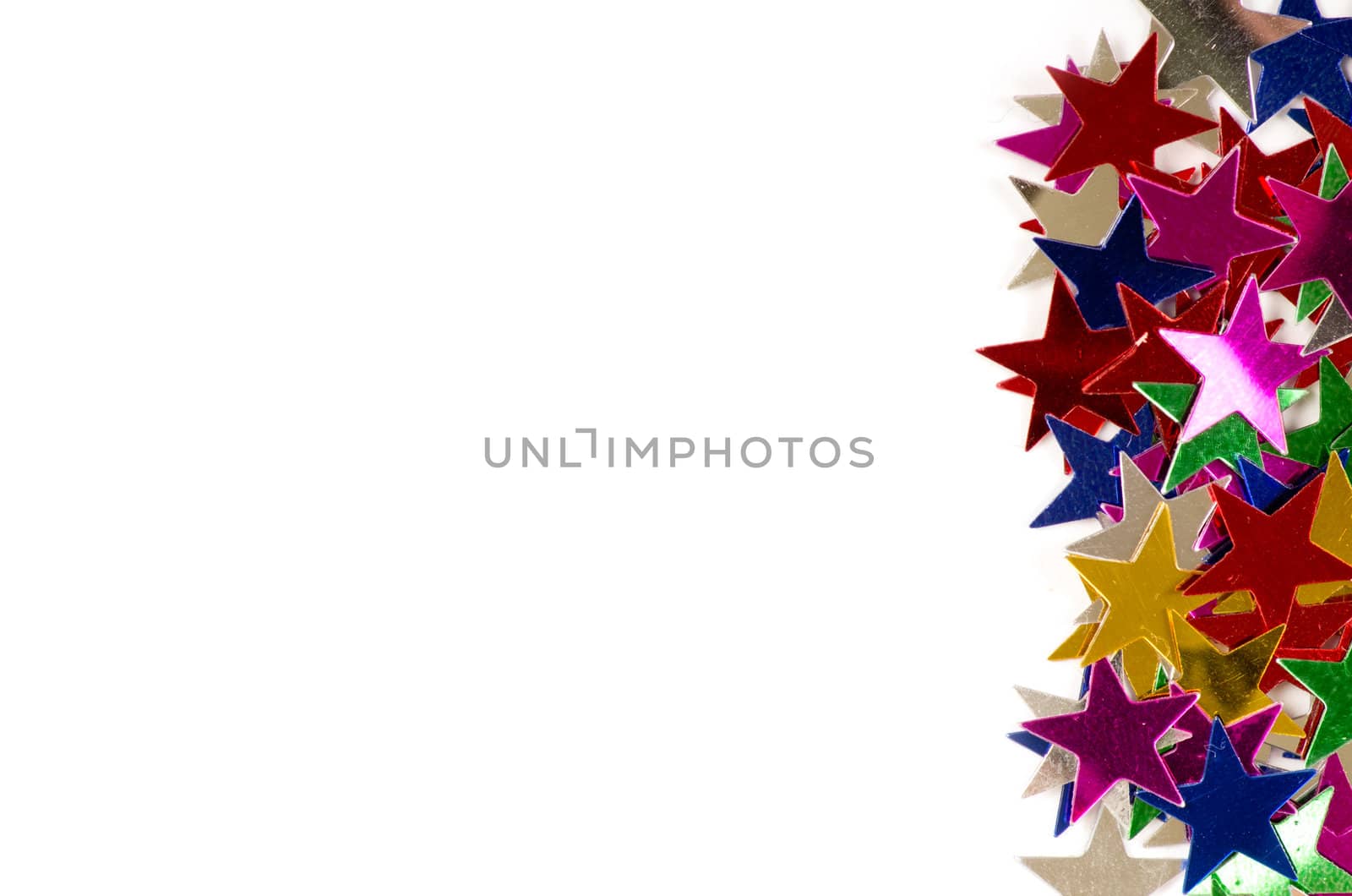 Christmas decoration of colored confetti stars against white background