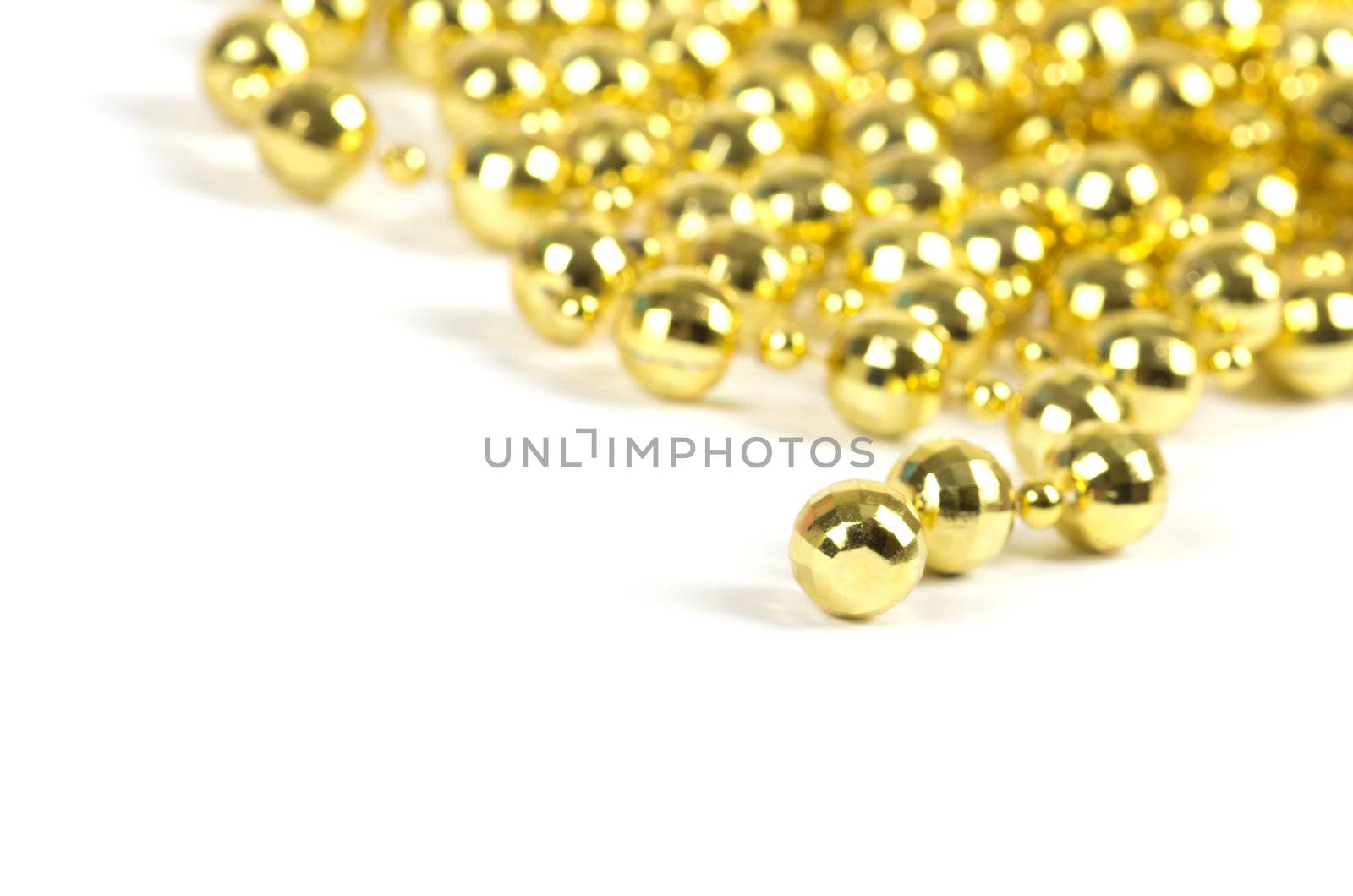 Background made of a brilliant celebratory beads of golden color over white