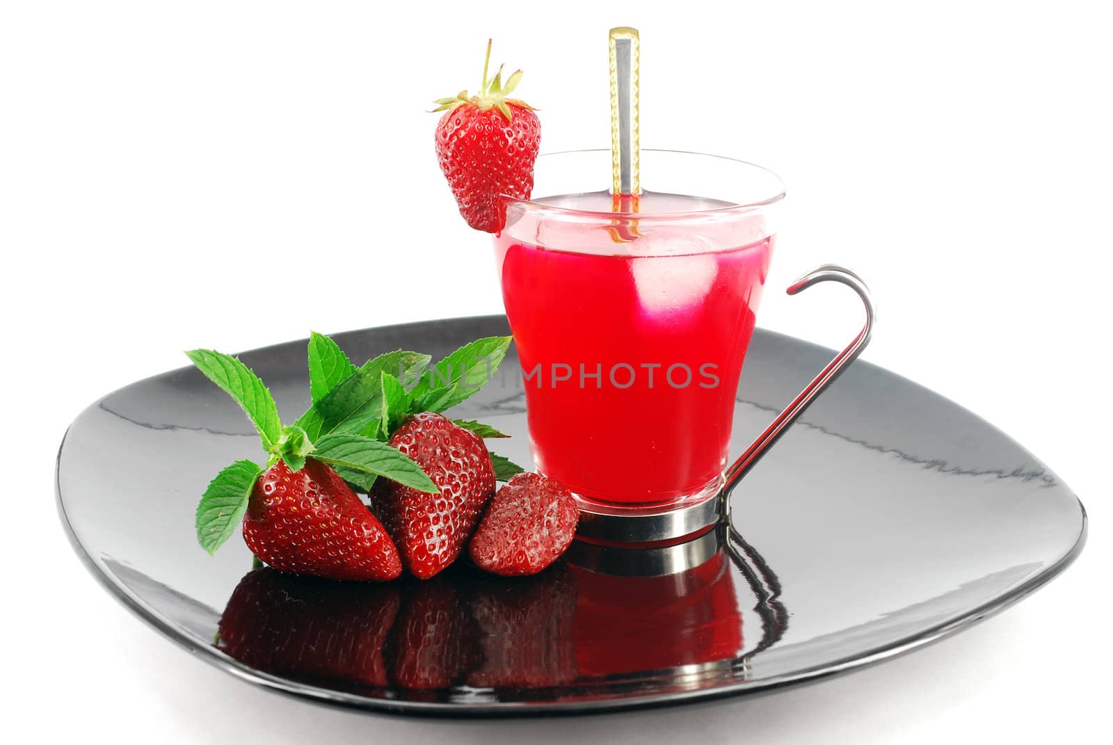 Ice tea with strawberries on black dish
