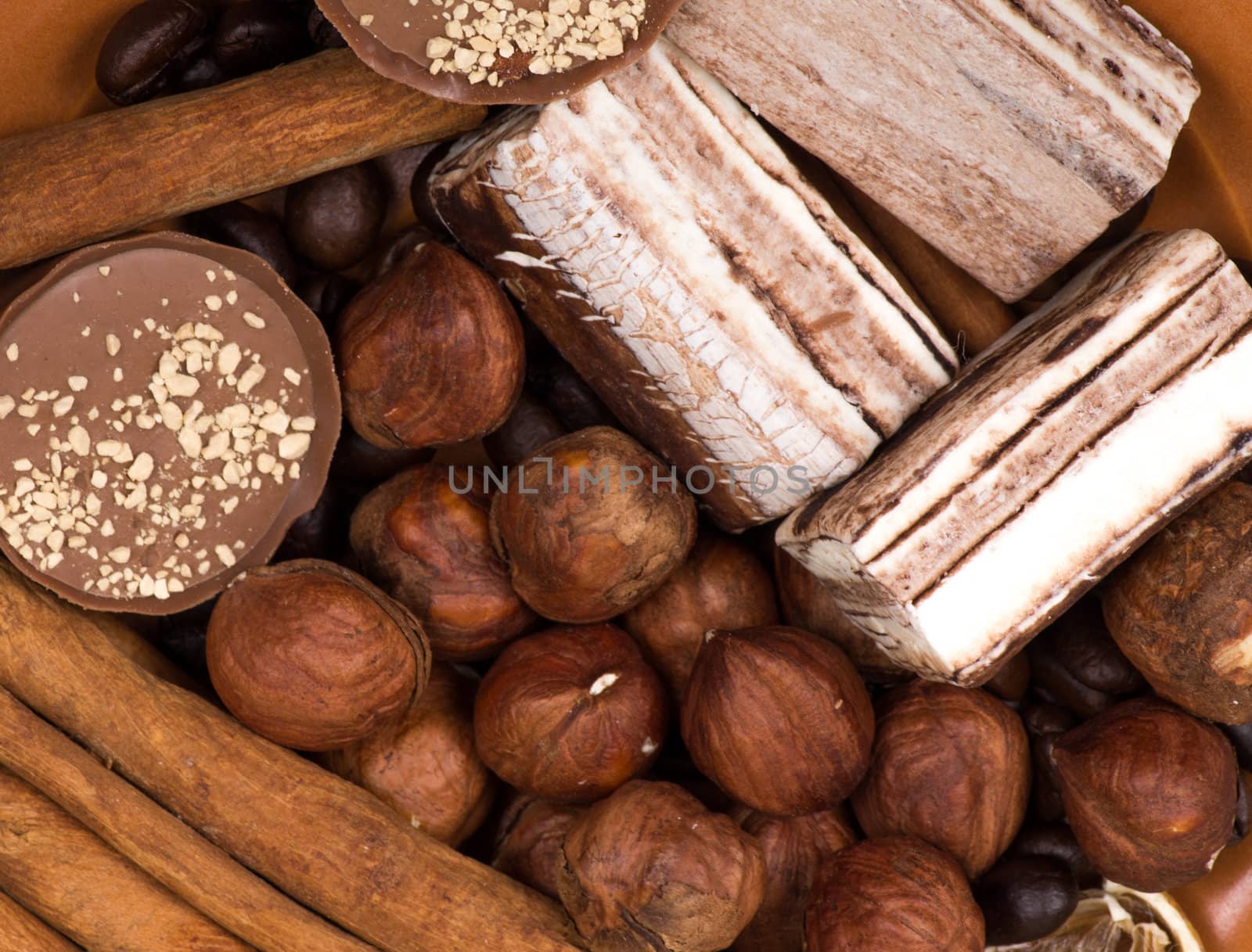 Sweets, cinnamon, nuts and coffee beans on a saucer, on burlap background.