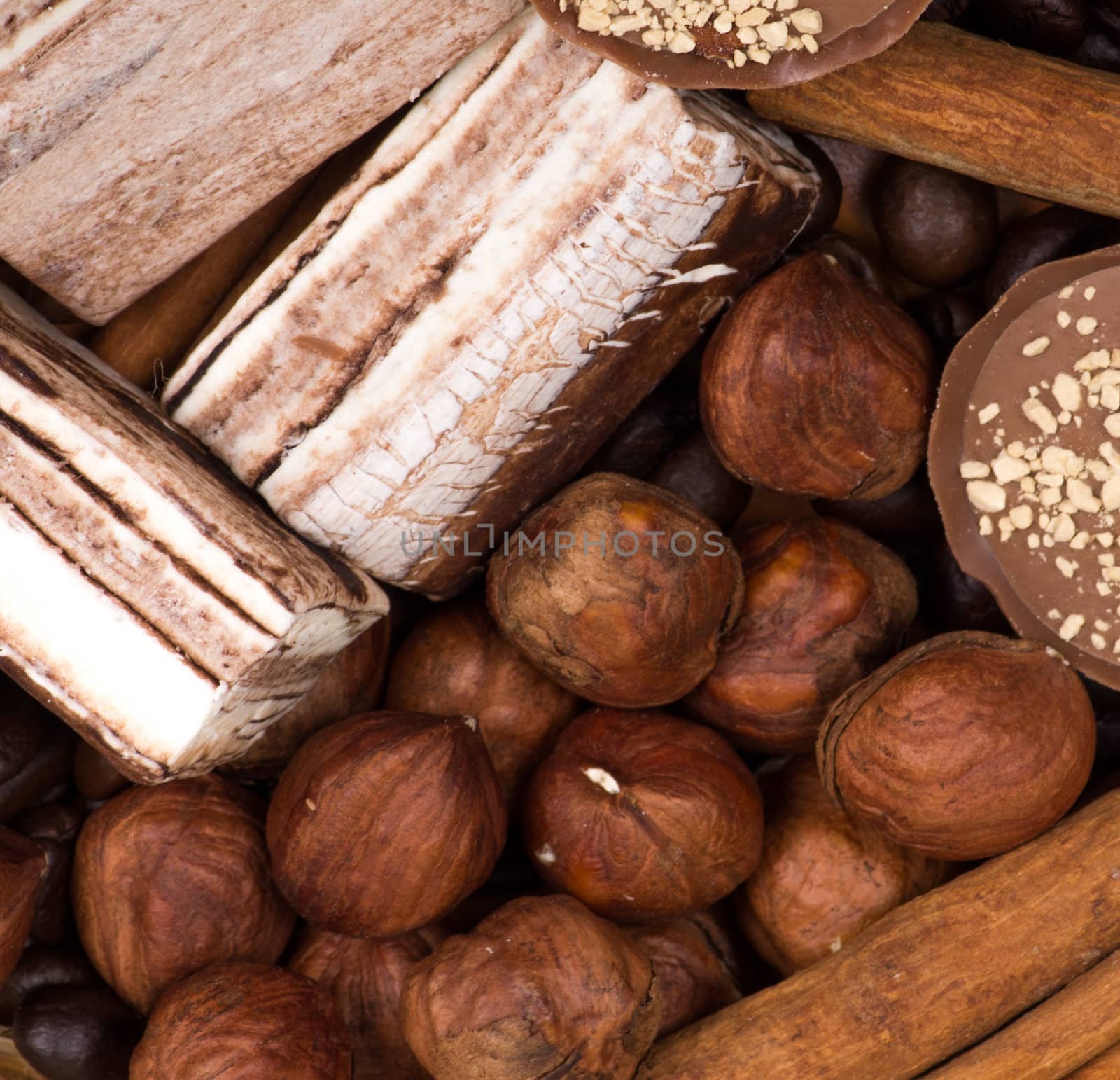 Sweets, cinnamon, nuts and coffee beans on a saucer, on burlap background.