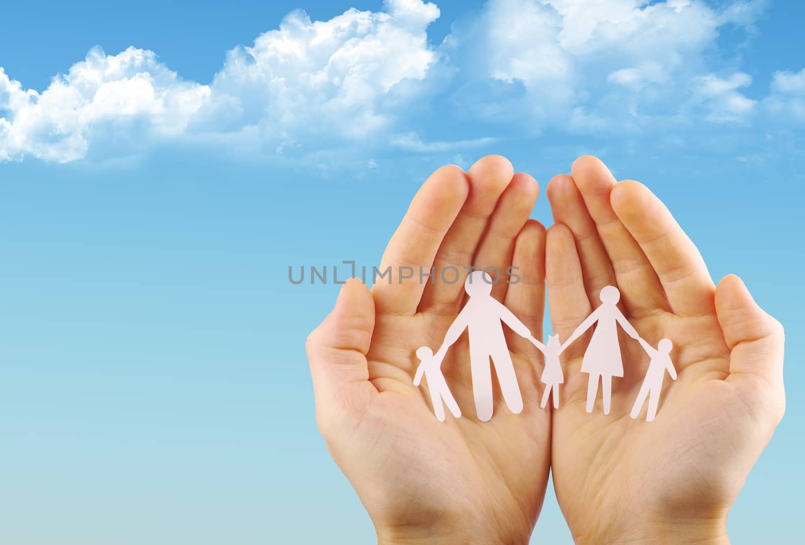 Paper family in hands isolated on blue sky
