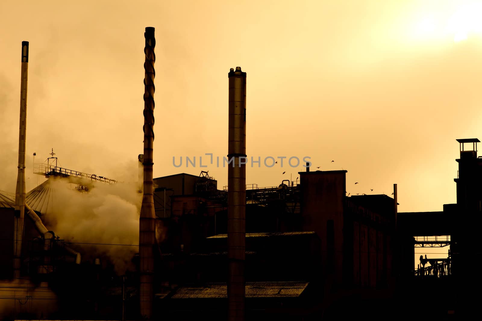 silhouette of an industrial premises with steam billowing out