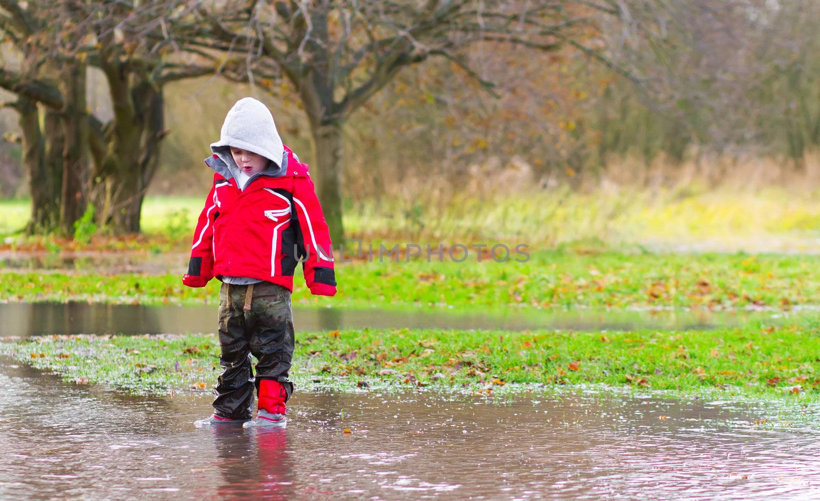 boy running in a large puddle