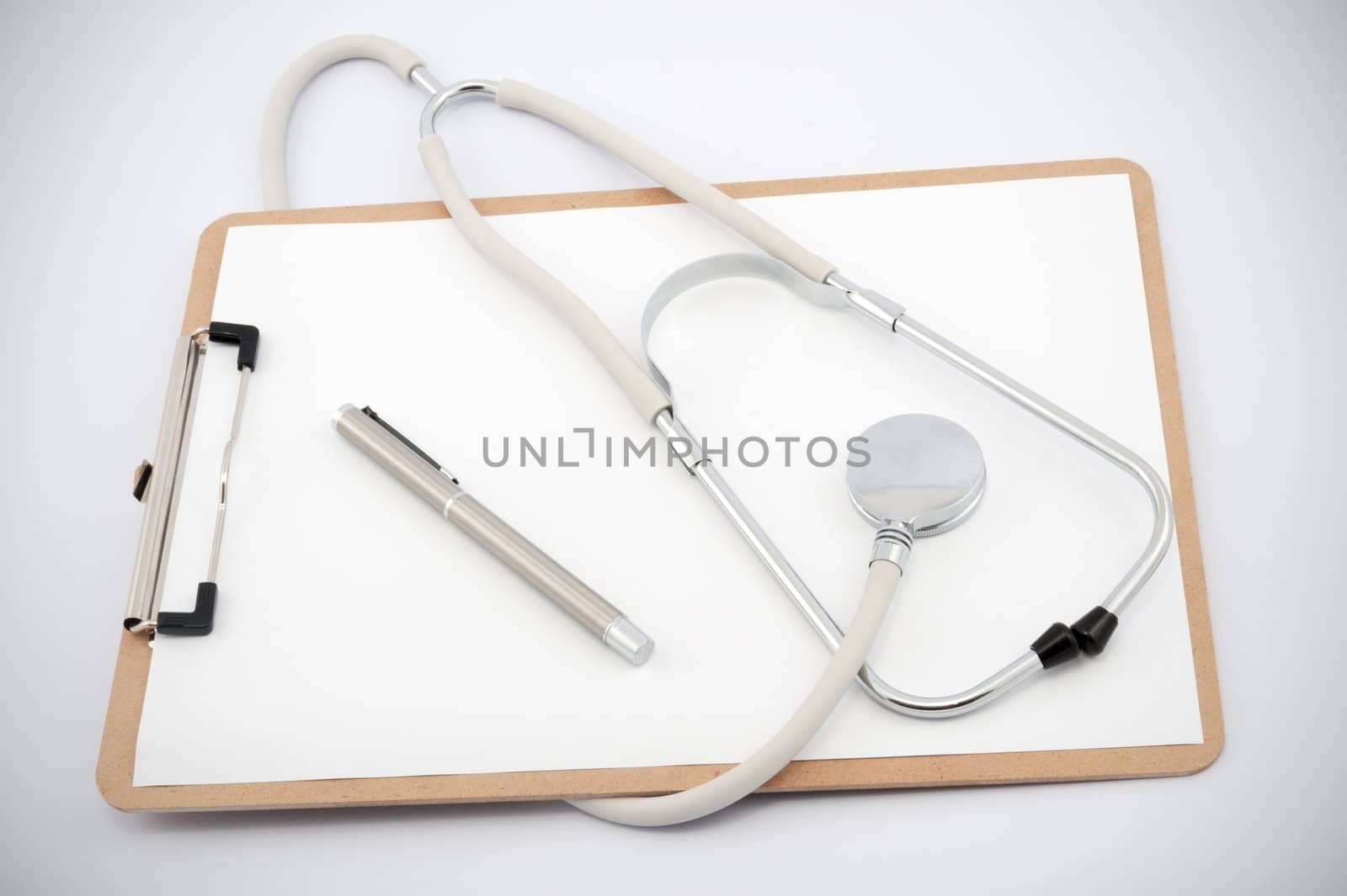 Stethoscope and clip board with blank paper on a white background.