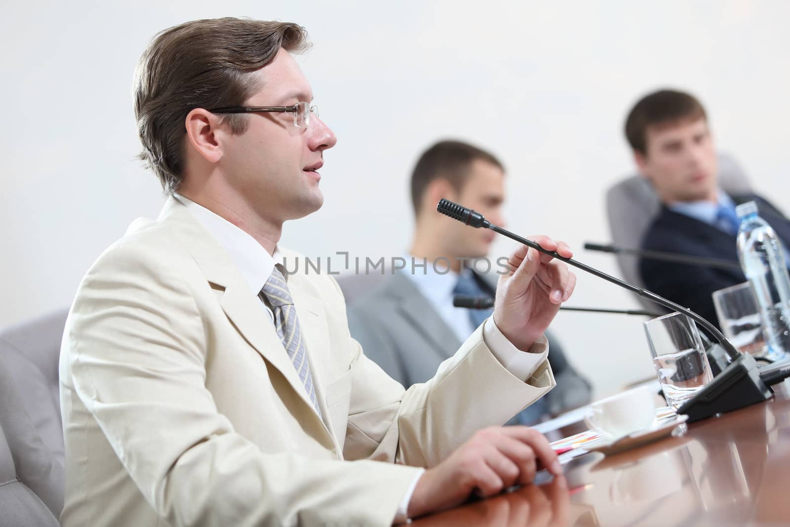 Image of three businesspeople at table at conference