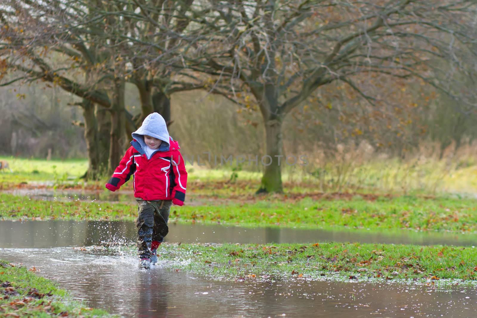 boy running in a large puddle