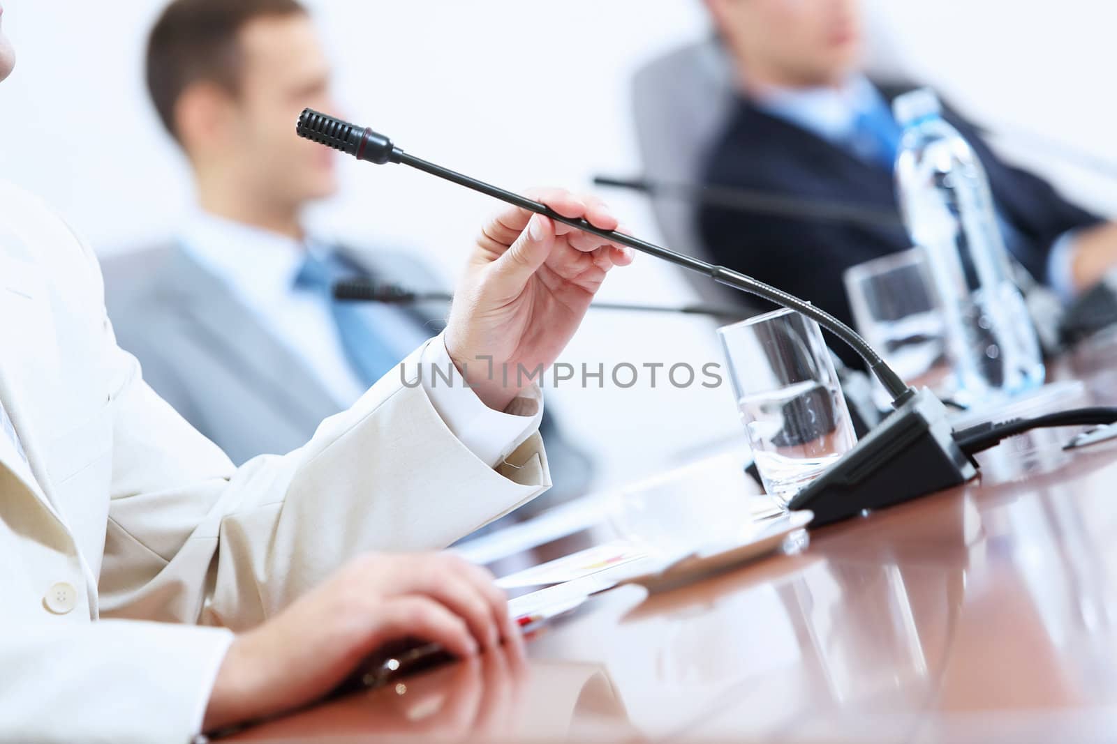 Hands of businessman holding microphone by sergey_nivens