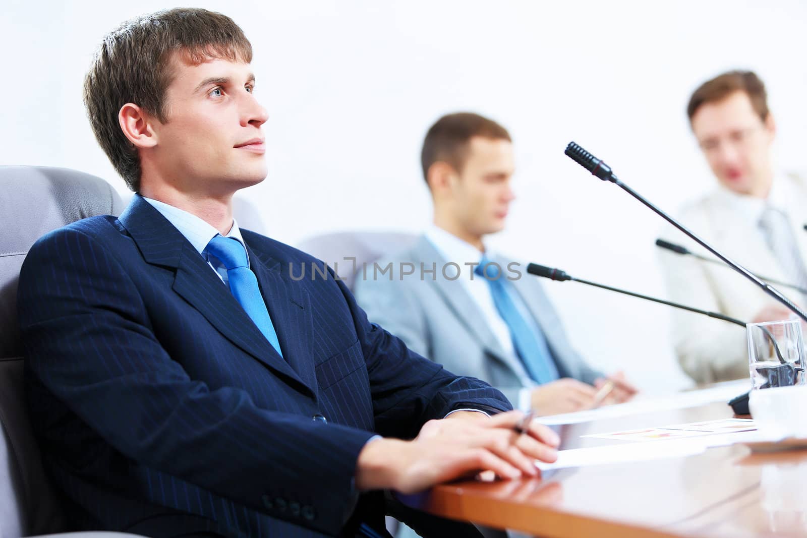 Image of three businesspeople at table at conference