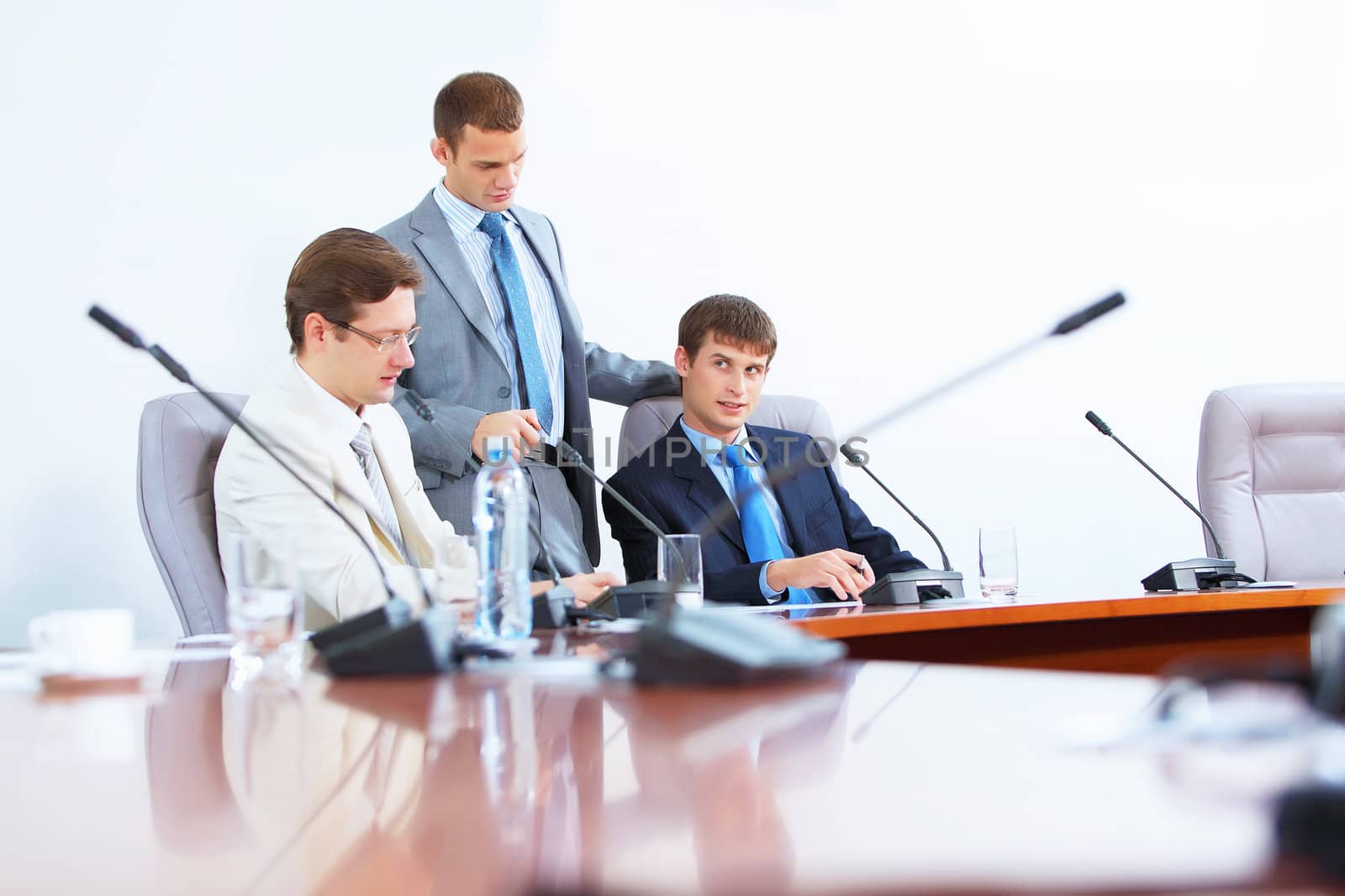 Image of three businesspeople at table at conference