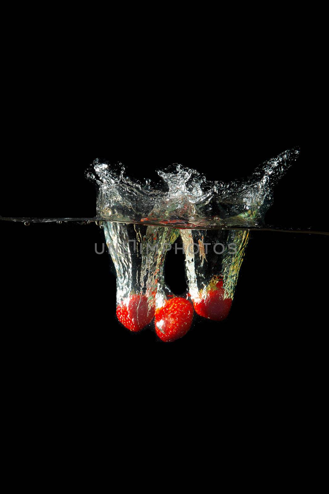 Colored red paprika in water splashes on black background