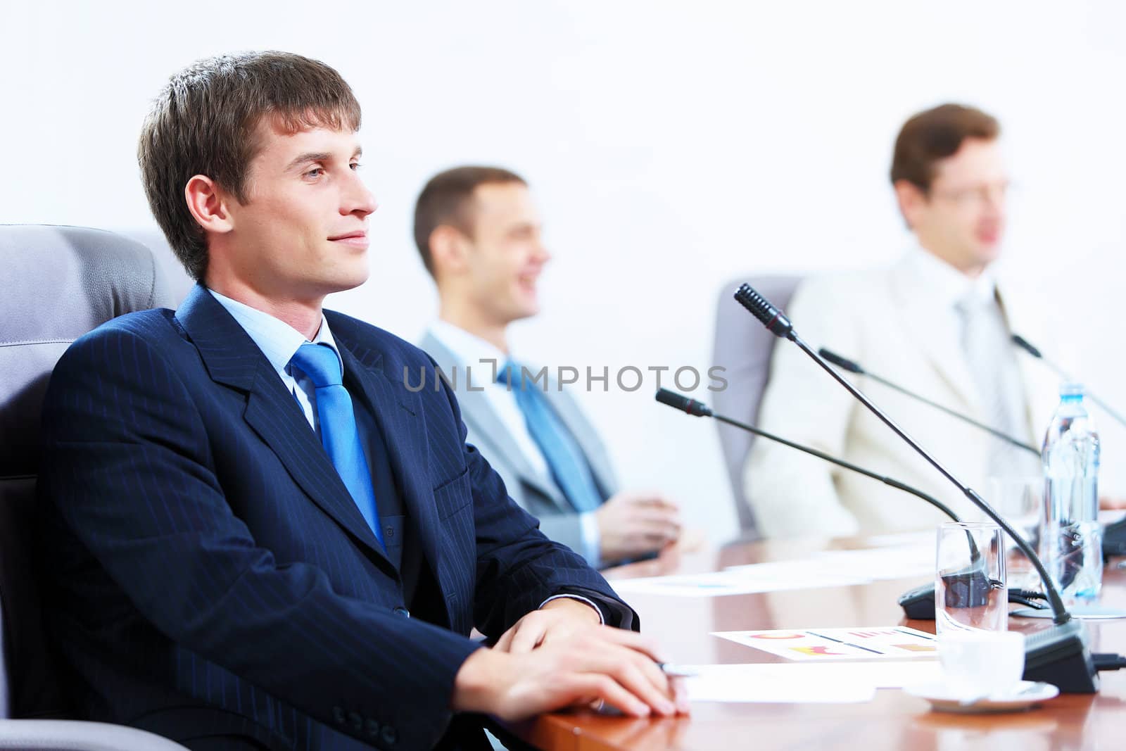 Image of three businesspeople at table at conference