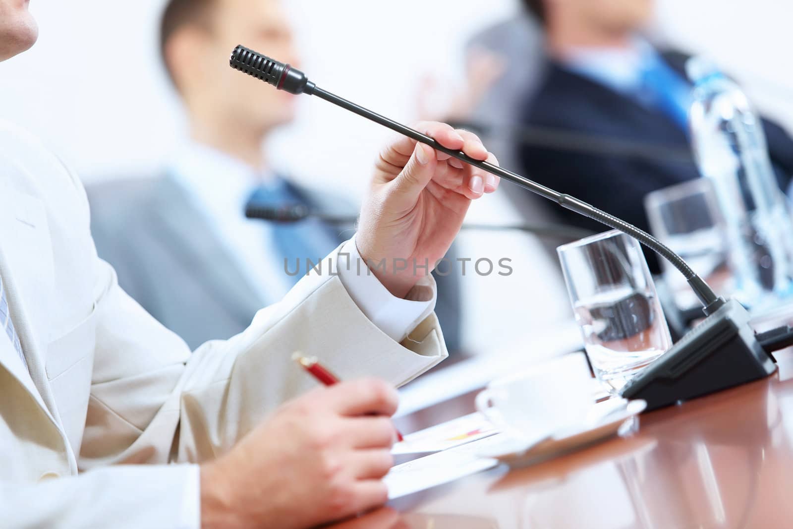 Hands of businessman holding microphone by sergey_nivens