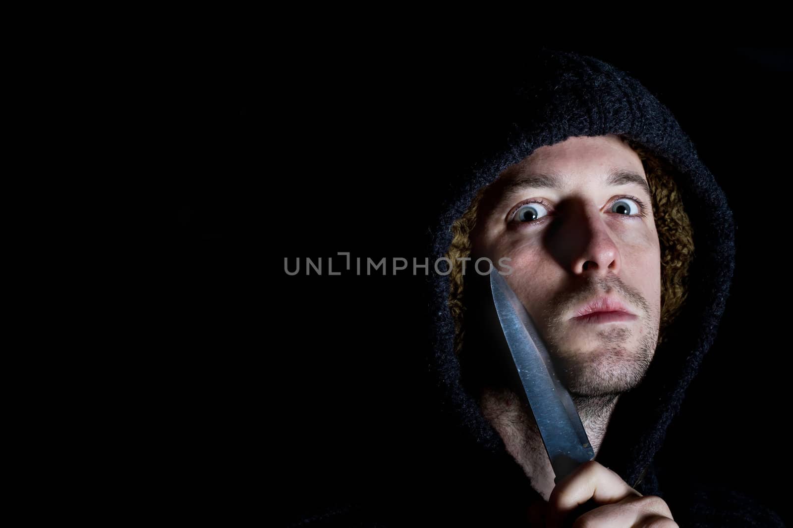 robber with a knife about to commit a crime