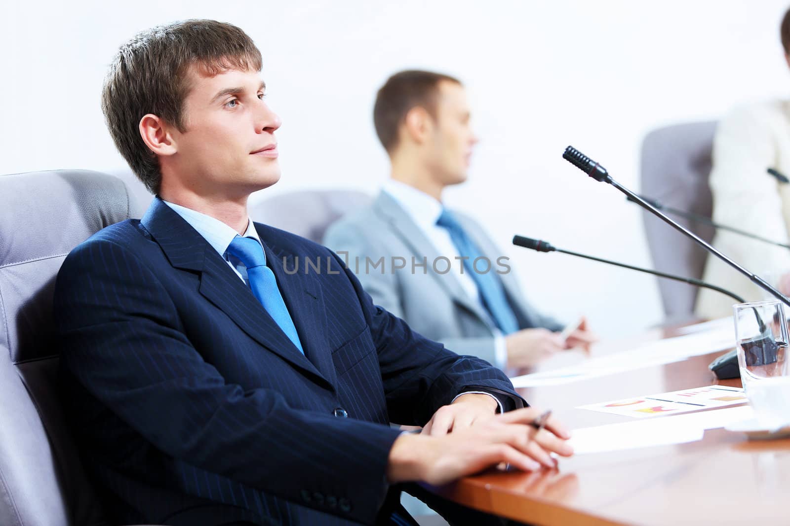 Image of three businesspeople at table at conference
