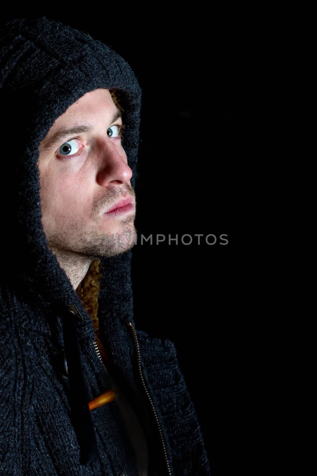 angry violent man with hood up staring