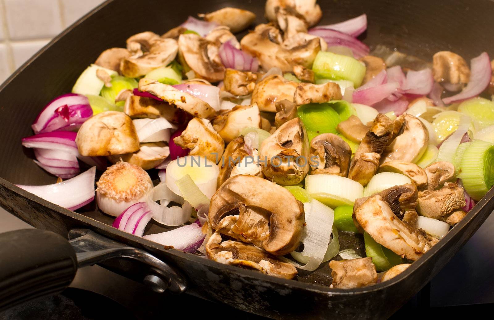 Mushrooms, Leeks and red onions frying in a pan