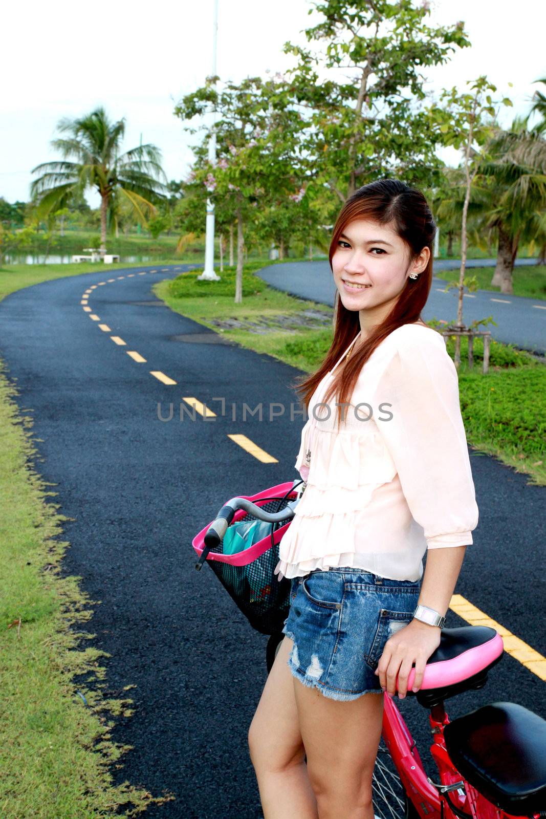 asian women and bicycle on the road at the park by geargodz